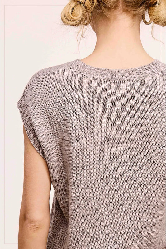 Light brown knitted sleeveless top worn by a person on a white background
