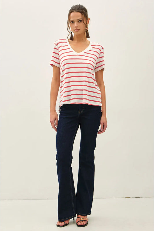 Woman wearing a red and white striped shirt and dark blue jeans on a white background