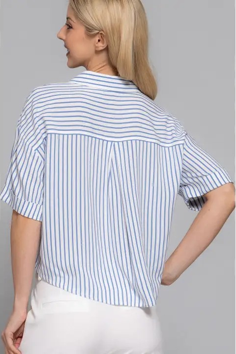 Woman wearing a blue and white striped shirt against a gray background