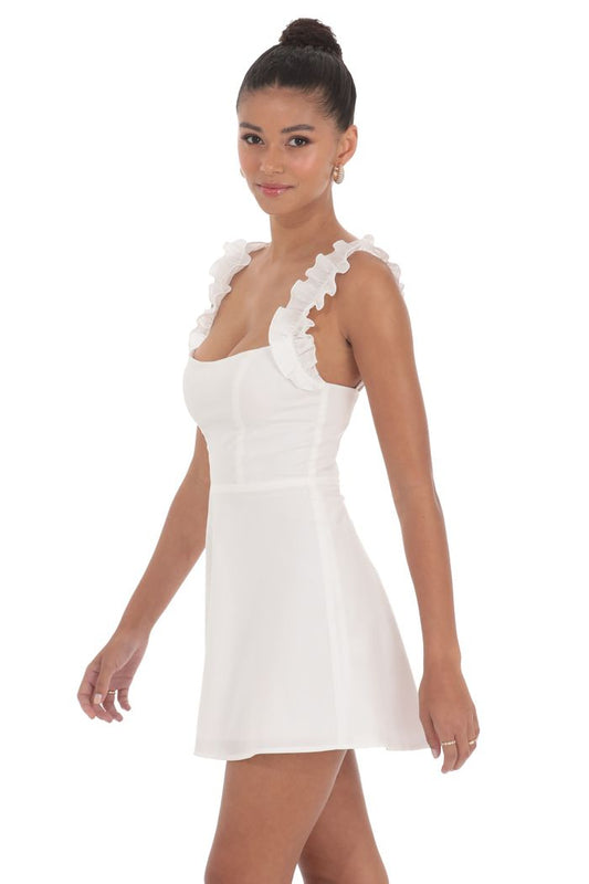 Woman wearing a white dress with floral details on a white background