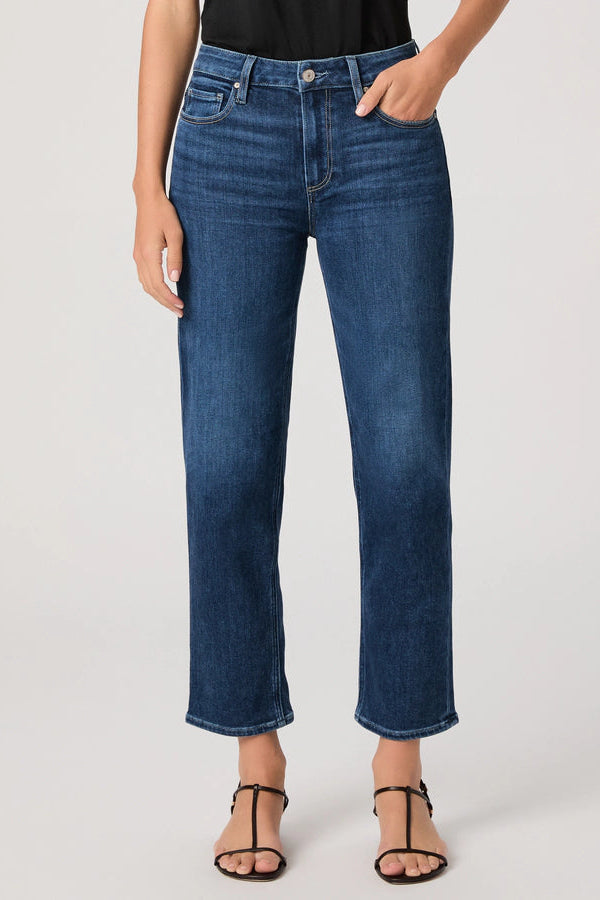 Person wearing blue jeans on a plain background