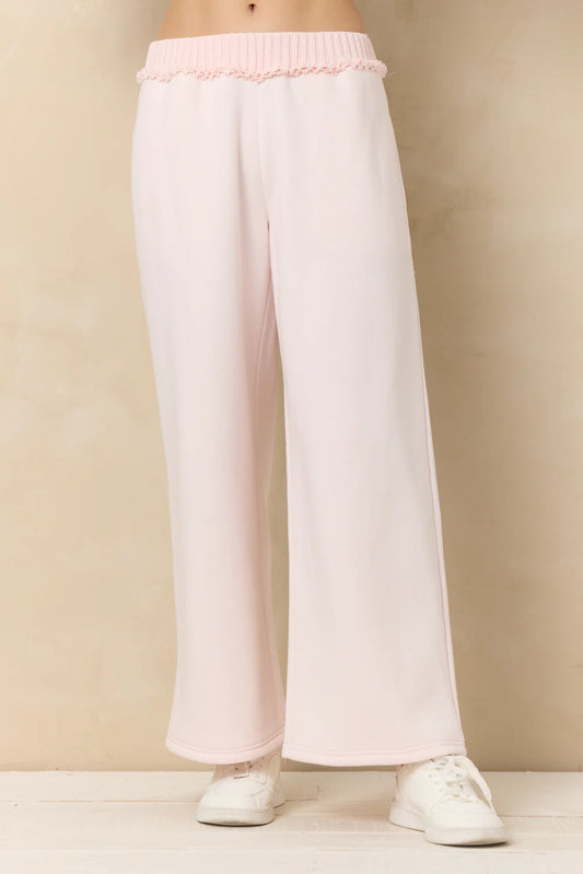 White pants with pink waistband on a beige background