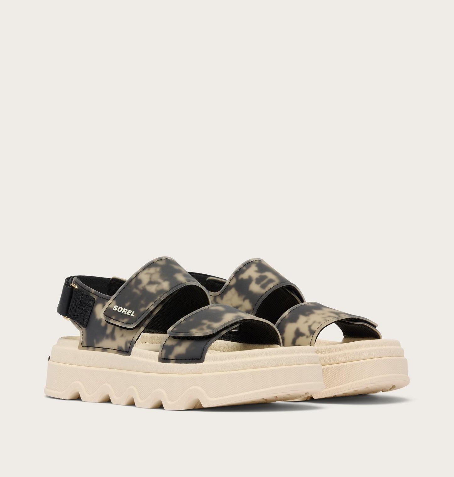 Camouflage-patterned sandal with a white sole on a light gray background