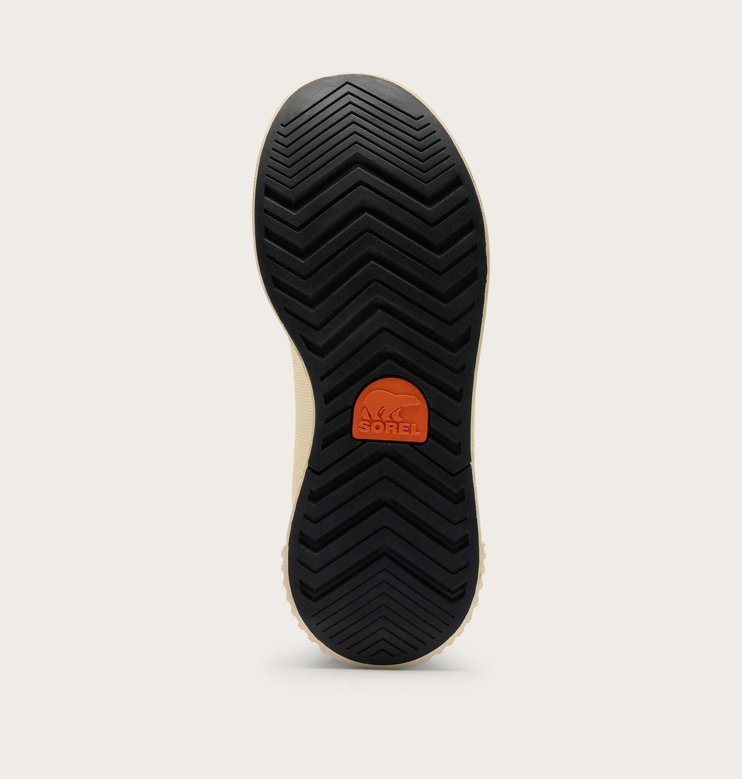 The black treaded outsole of a shoe, showing the SOREL logo in orange on the heel, photographed against a light beige background.