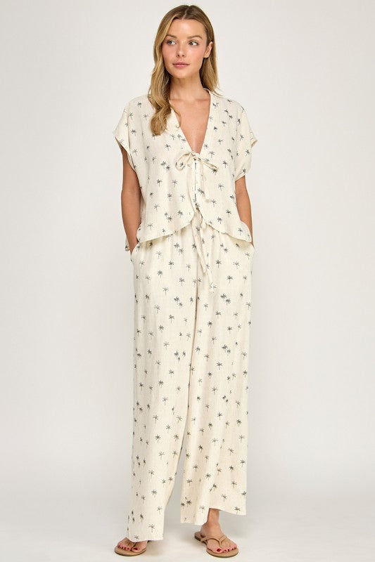 Woman wearing a cream-colored jumpsuit with a subtle pattern on a white background