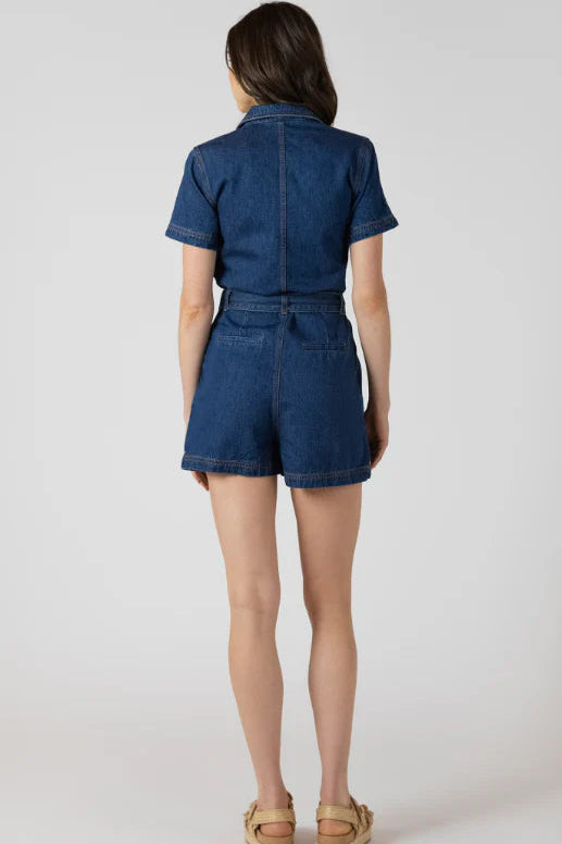 Woman wearing a denim romper on a white background