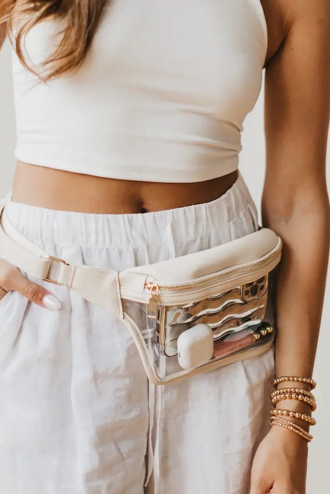 Person wearing a white top and light-colored pants with a clear fanny pack.