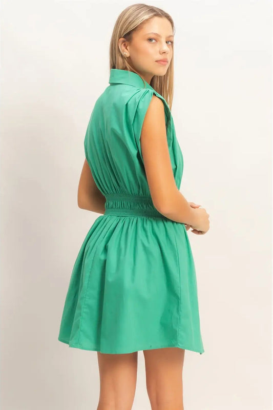 Woman wearing a green dress against a plain background