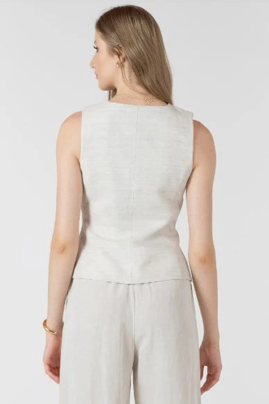 Woman wearing a light gray sleeveless top and pants on a white background