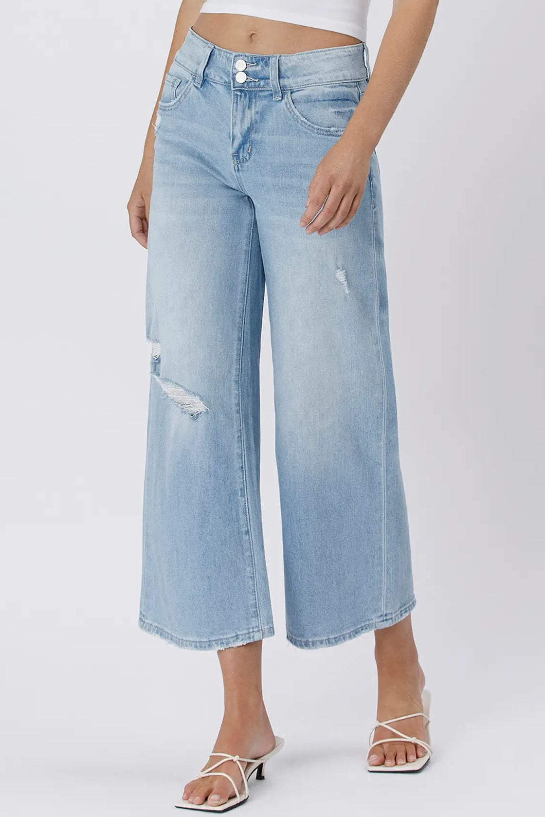 Light blue denim jeans worn by a person on a white background