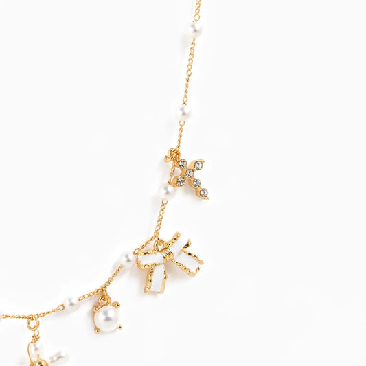 Gold necklace with star and pearl pendants on a white background