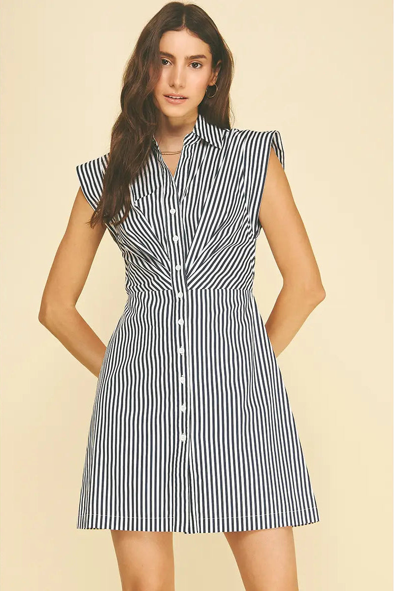 Woman wearing a black and white striped dress on a beige background
