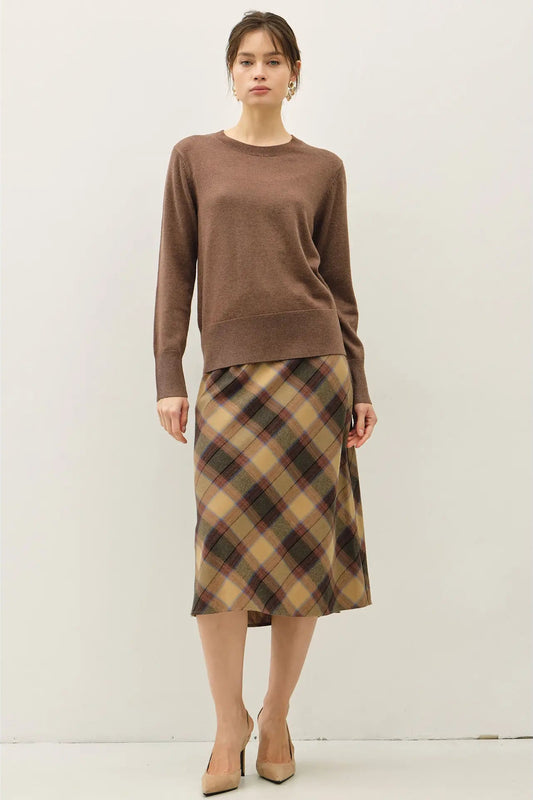 womand in brown sweater and plaid skirt