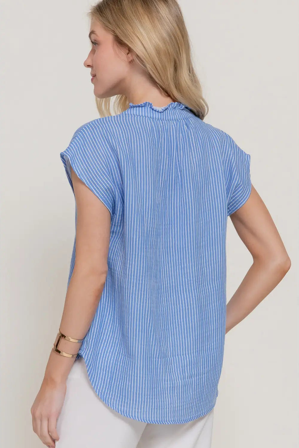 Woman wearing a blue striped shirt against a plain background