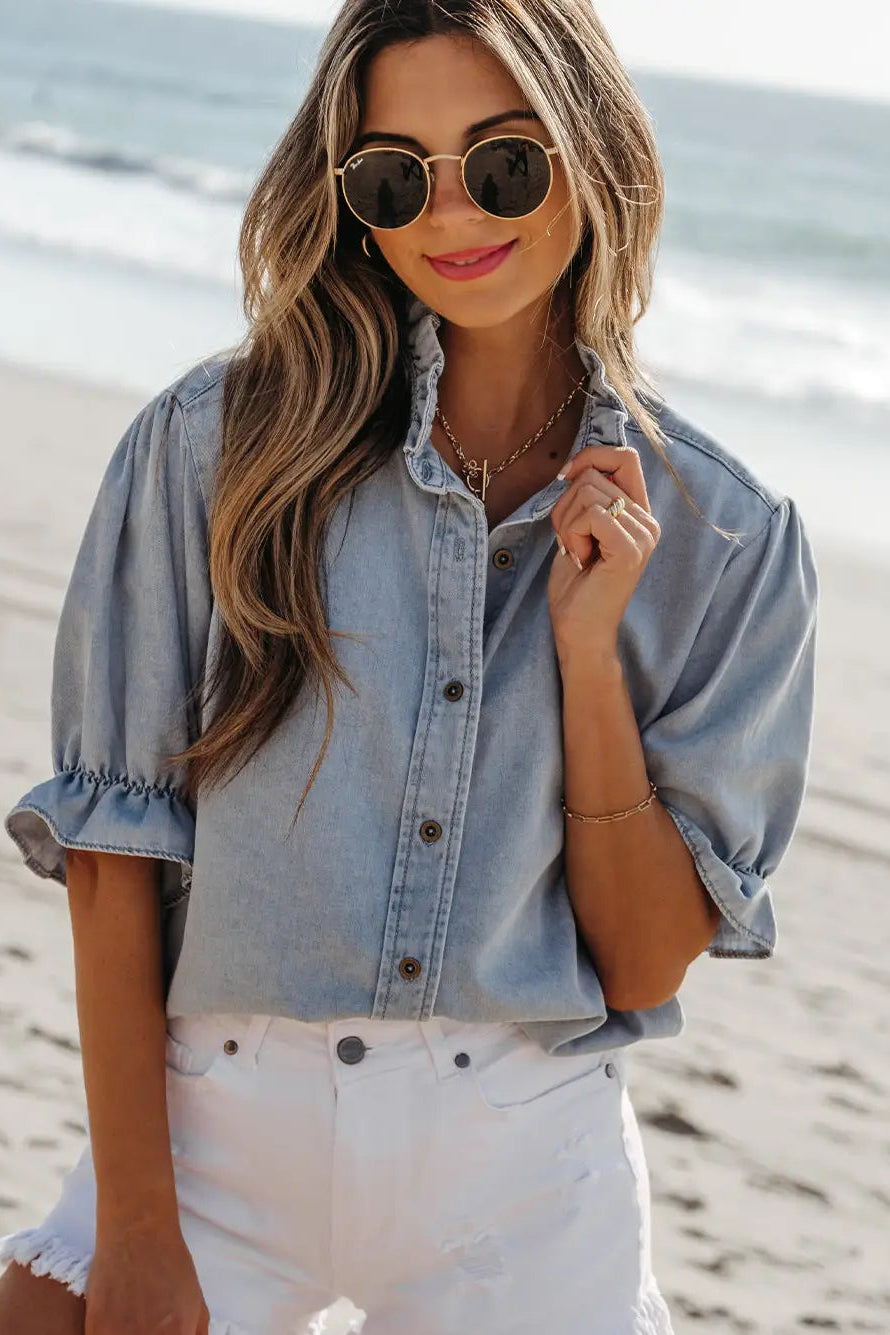 Woman wearing a denim shirt and white shorts on a beach