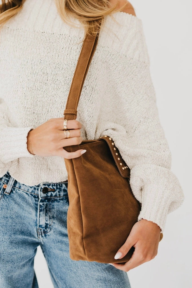 person holding suede bag