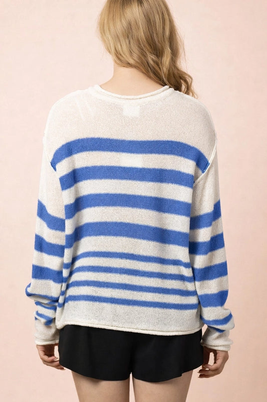 Person wearing a blue and white striped sweater on a pink background