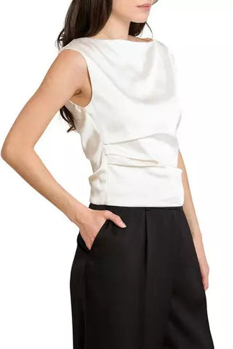 A woman wearing a sleeveless white top with a draped, layered back design and black wide-leg pants, shown from a side-back angle against a plain white background.