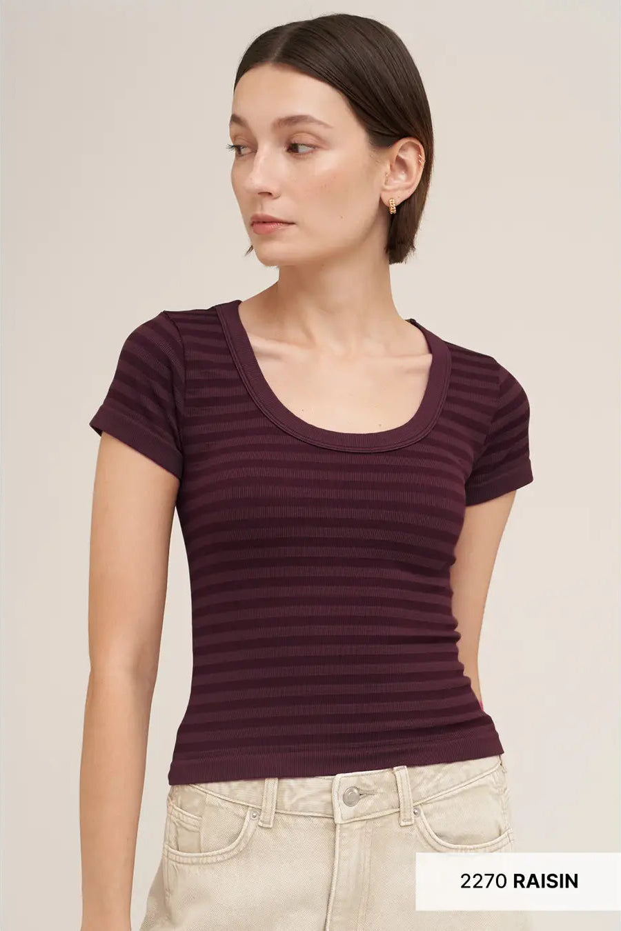 A woman wearing a short-sleeve scoop-neck ribbed top in a deep plum purple color, paired with light beige jeans. The image has a text label in the bottom right corner reading '2270 RAISIN'.