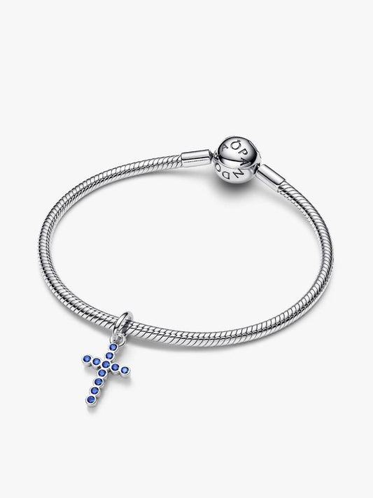 Silver bracelet with a cross charm on a white background