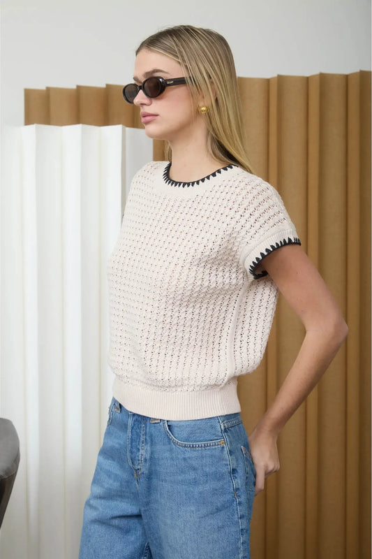 woman wearing cream short sleeve sweater with jeans