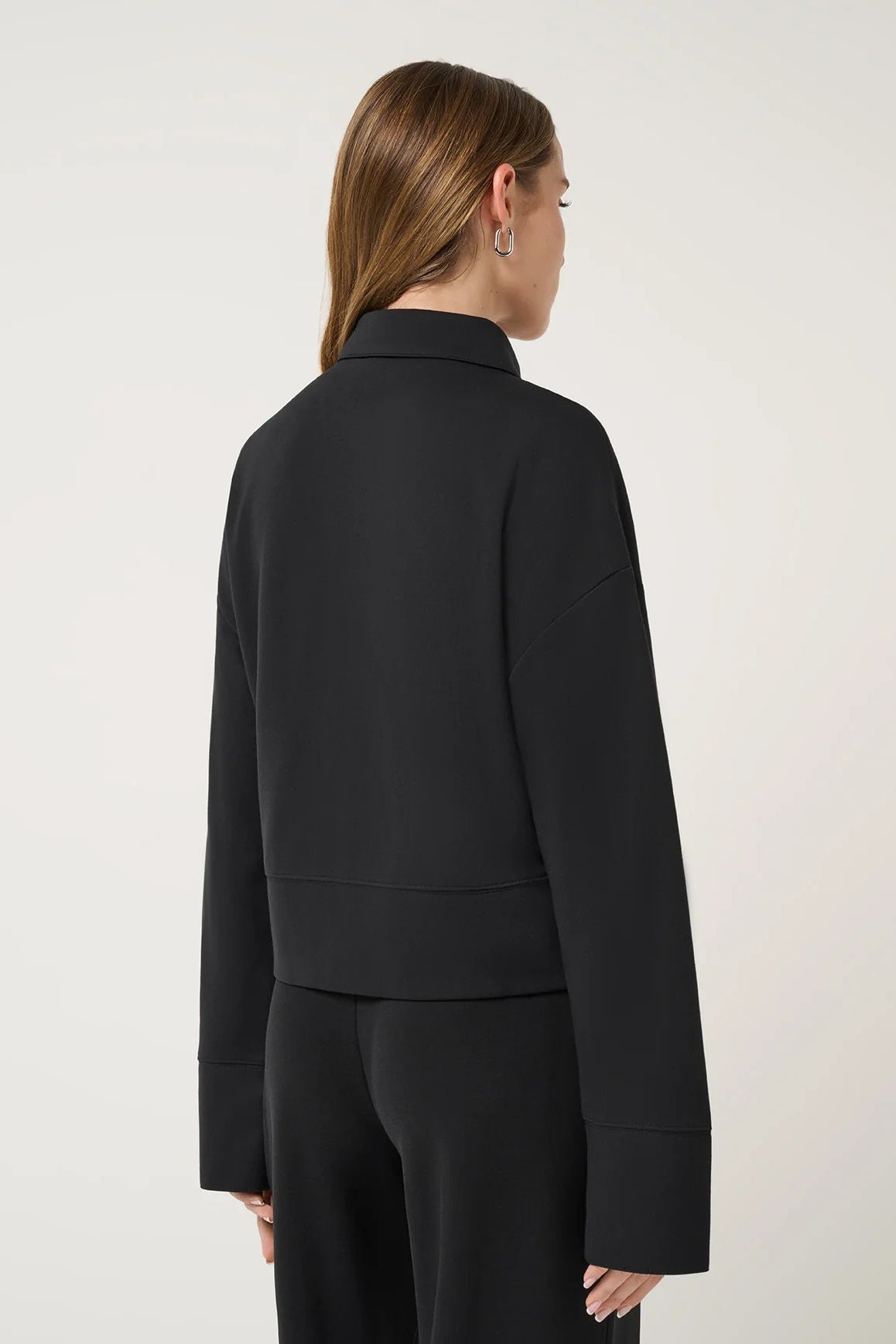 back view of woman in black jacket and pants