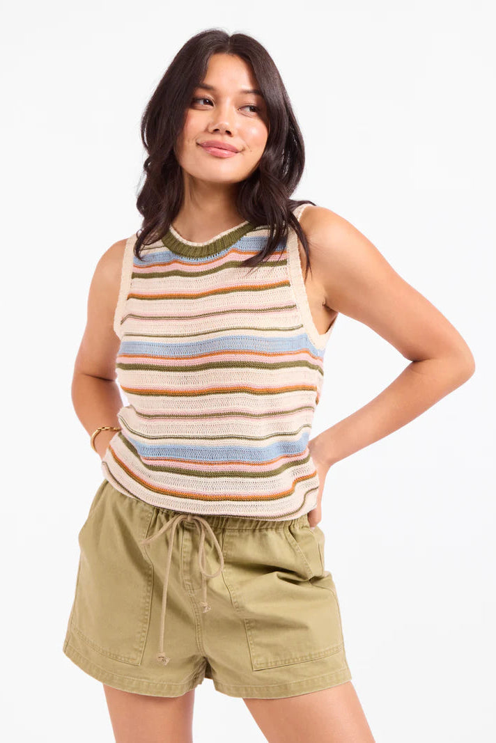 Woman wearing a striped sleeveless top and shorts on a white background