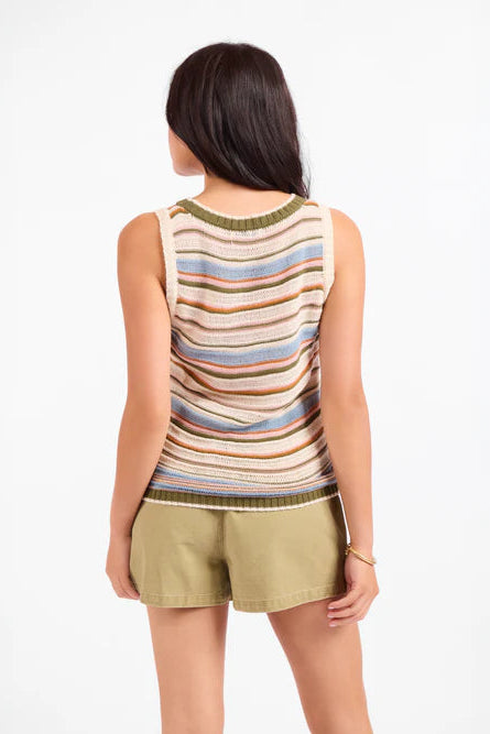 A woman shown from the back wearing a sleeveless knit top with horizontal stripes in beige, blue, brown, and olive green, paired with khaki shorts, against a plain white background.