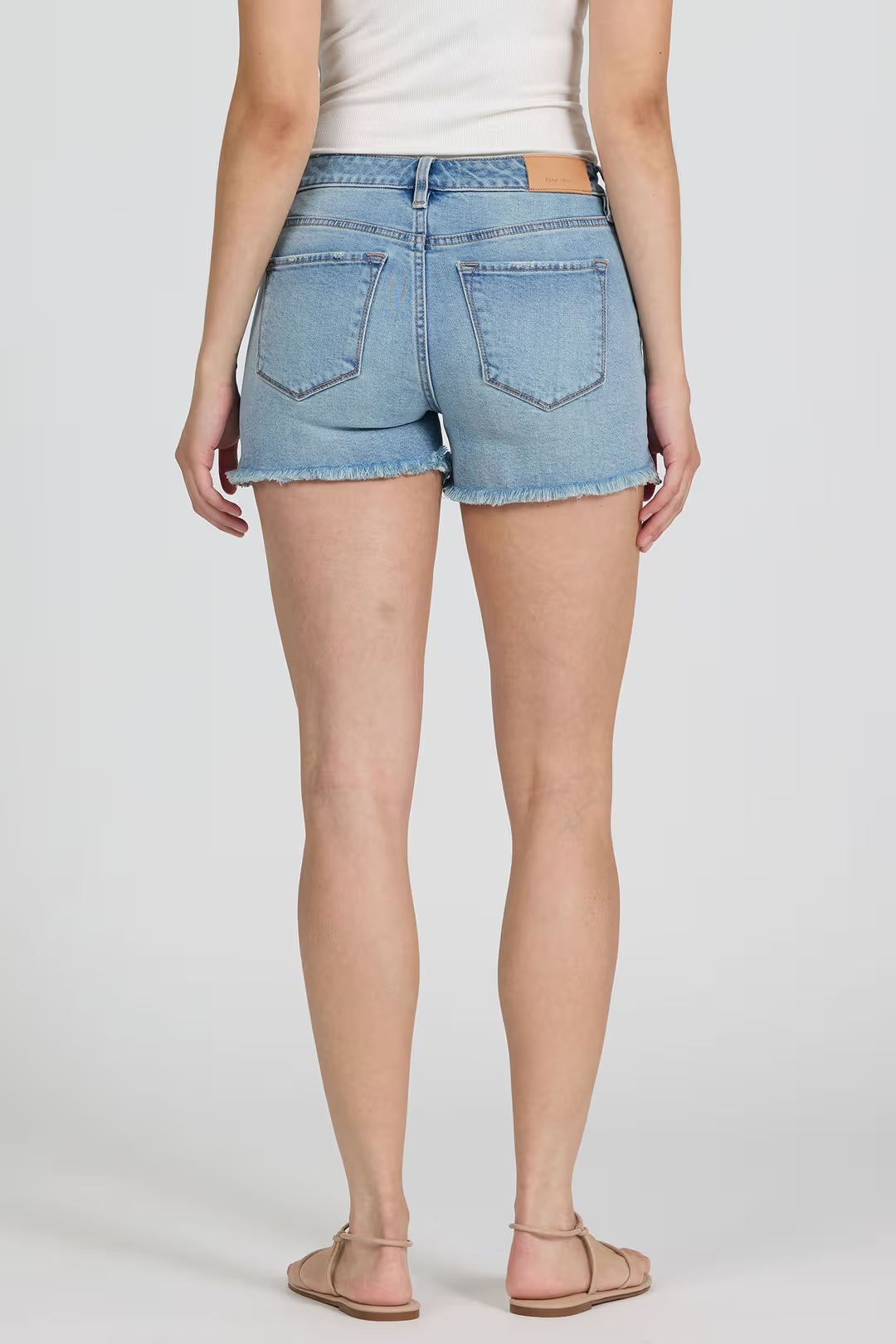 Light blue denim shorts worn by a person on a white background