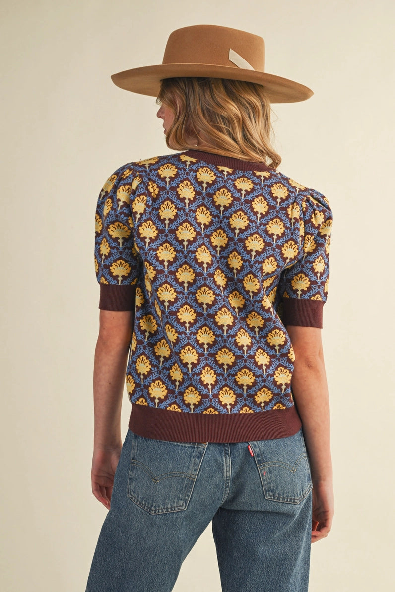 back view of woman in short sleeve floral sweater and jeans
