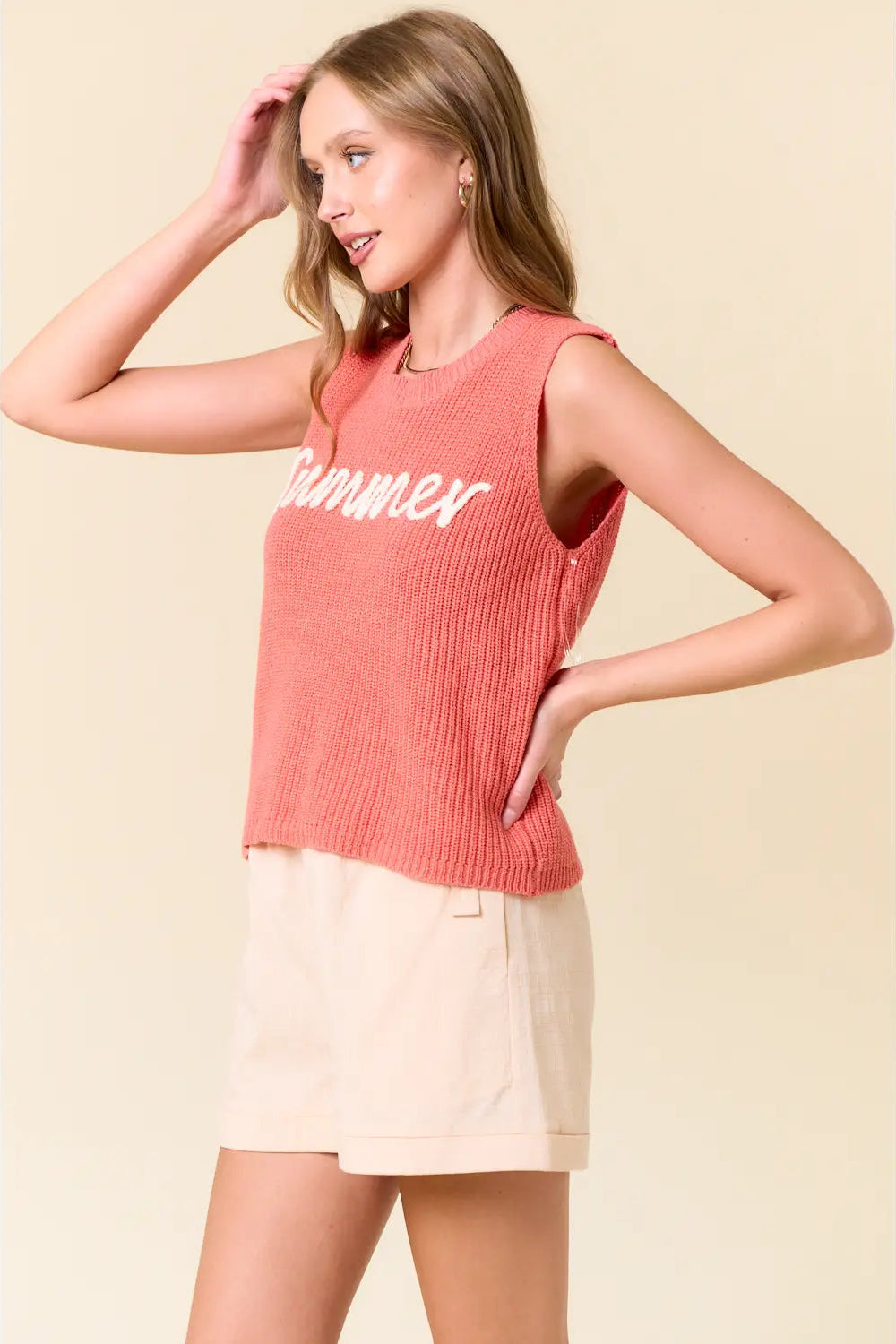 Woman wearing a coral sleeveless top with 'Summer' text on a beige background