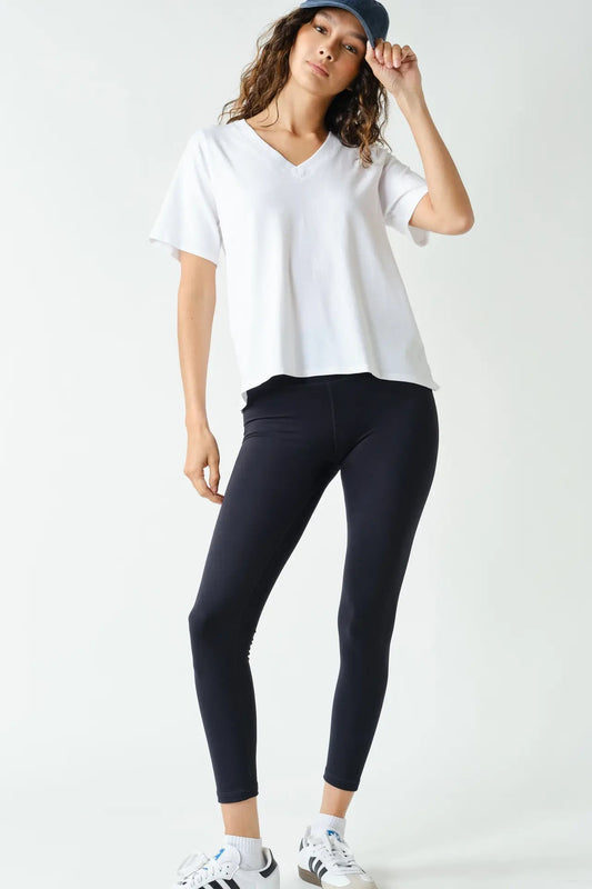 woman in white tee, hat and leggings