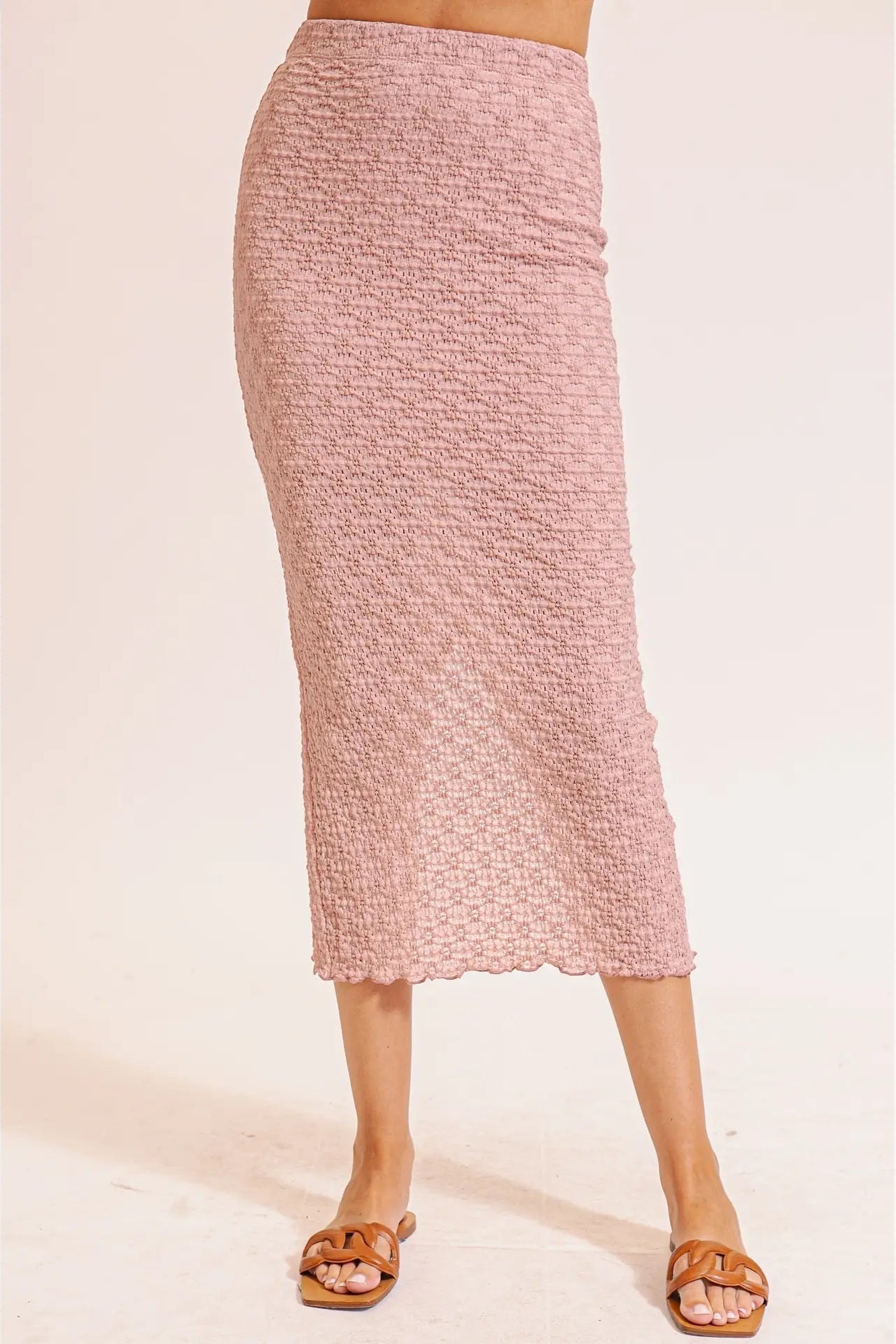 Pink textured skirt worn by a person on a light pink background