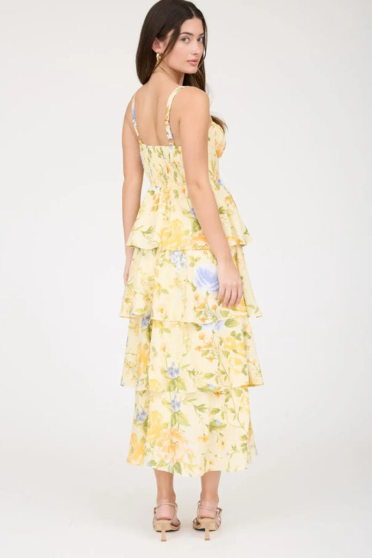 Woman wearing a yellow floral dress on a white background