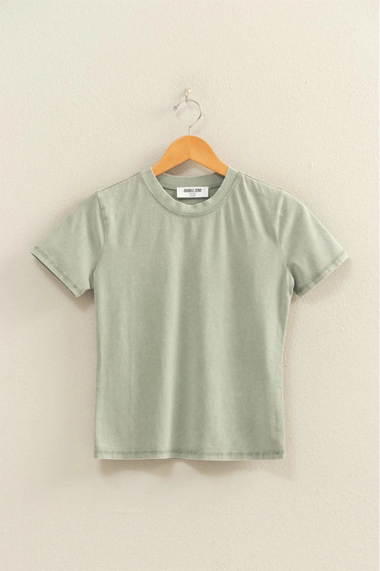 Green t-shirt on a hanger against a beige wall