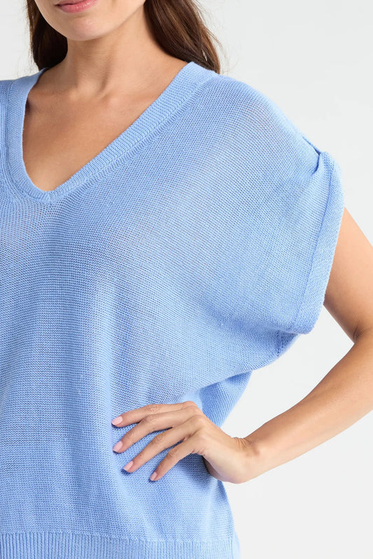 Light blue sleeveless sweater worn by a person on a white background