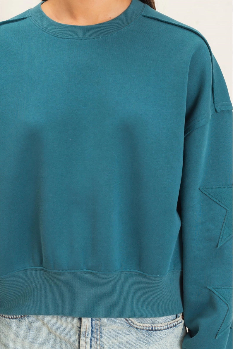 person wearing sweatshirt with stars on the sleeve