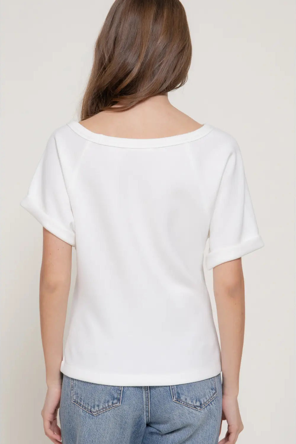 Person wearing a white t-shirt and blue jeans against a plain background