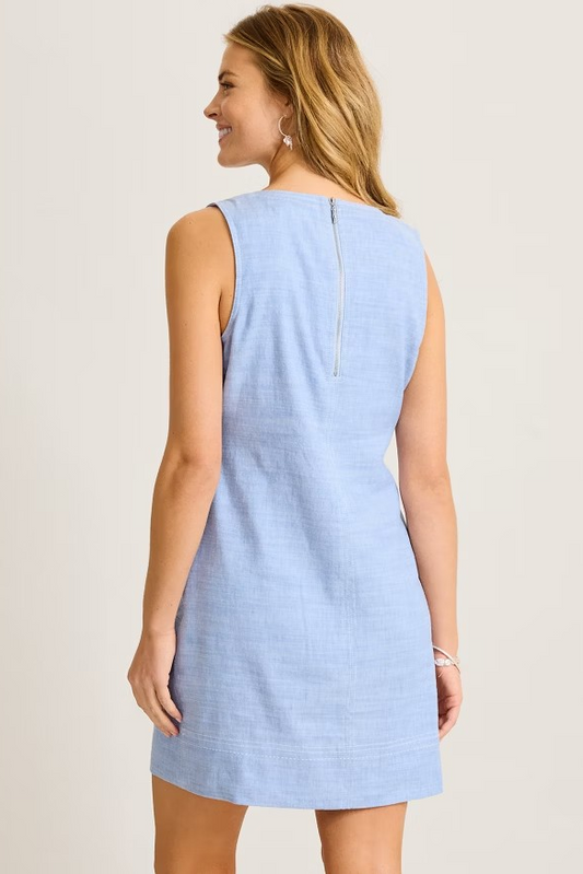 Woman wearing a light blue dress against a plain background