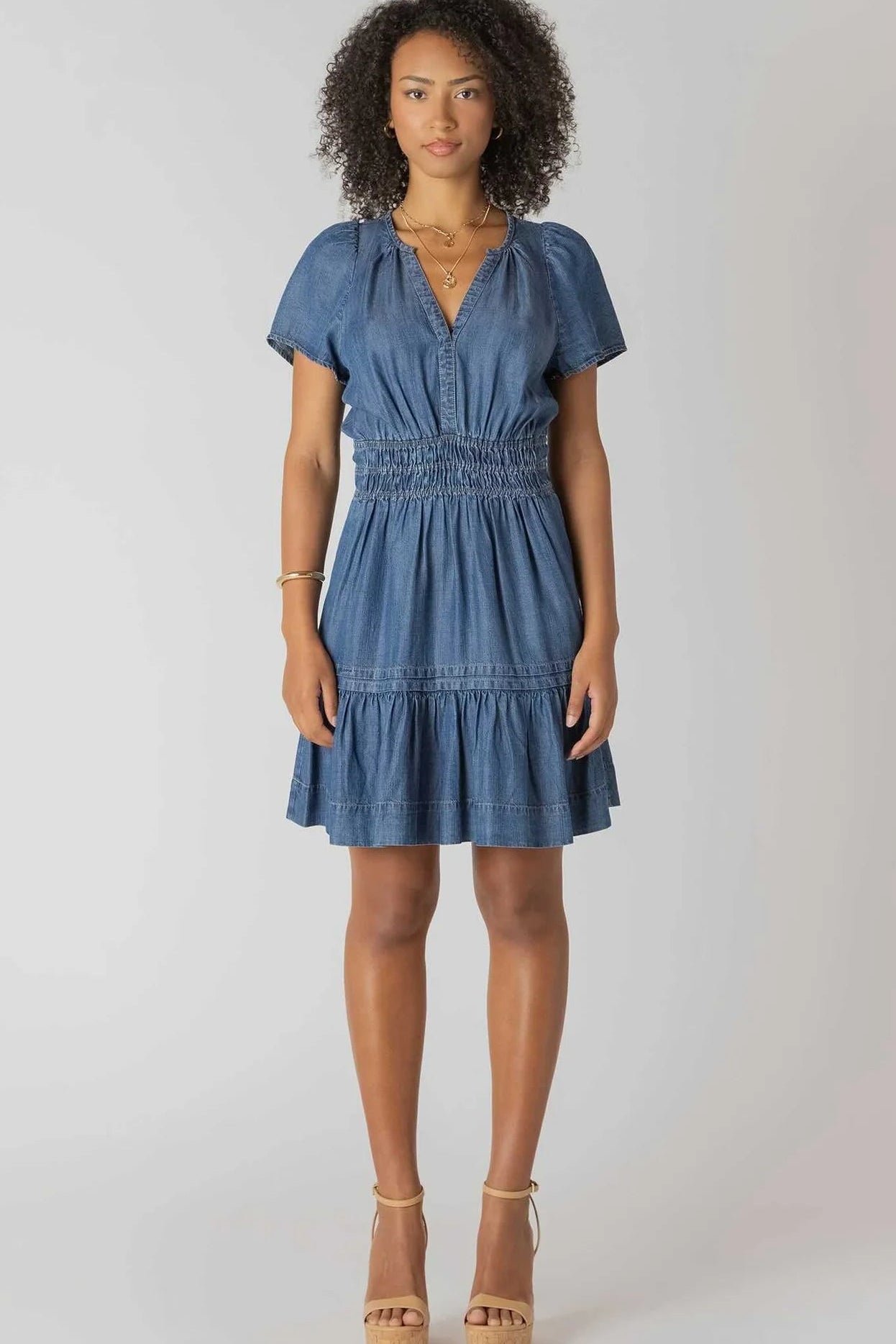 Woman wearing a blue denim dress on a white background