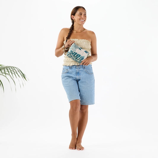 Woman wearing a strapless top and denim shorts on a white background