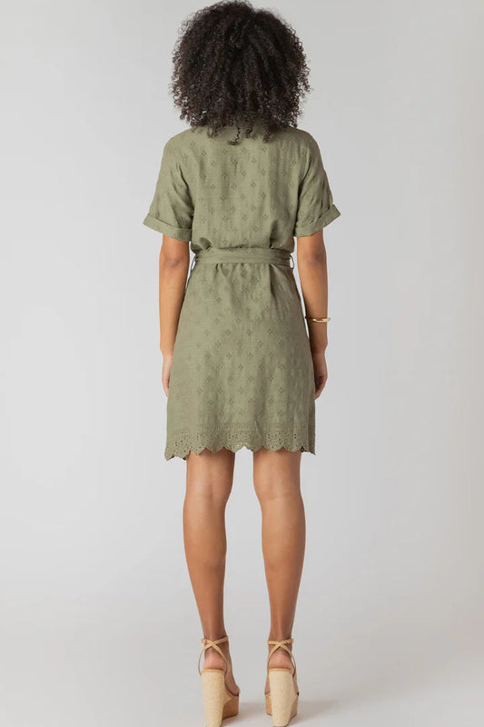 Person wearing a green dress with a belt on a white background