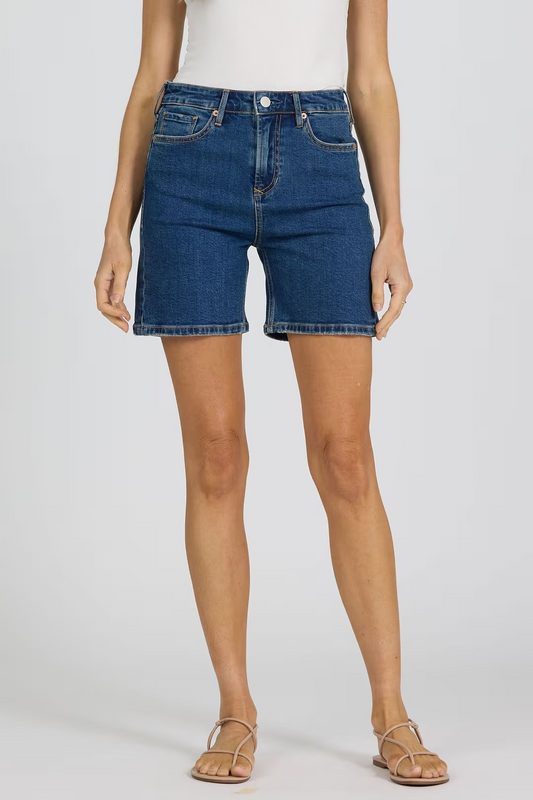 Person wearing blue denim shorts on a plain background