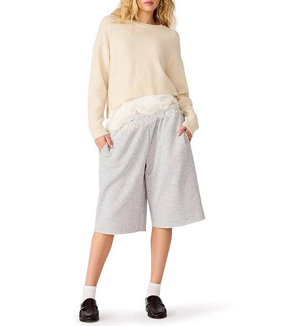 woman wearing cream sweater and gray pants