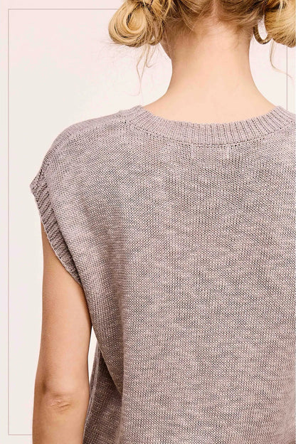 Light brown knitted sleeveless top worn by a person on a white background