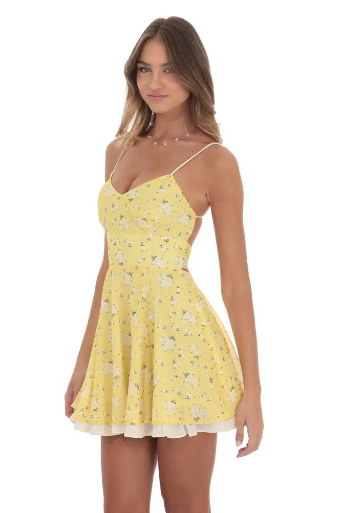 Woman wearing a yellow floral dress on a white background