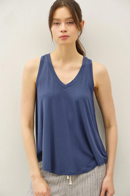 Woman wearing a blue tank top against a plain background