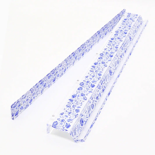 Two long narrow strips with a blue floral pattern on a white background, photographed on a clean white studio surface.