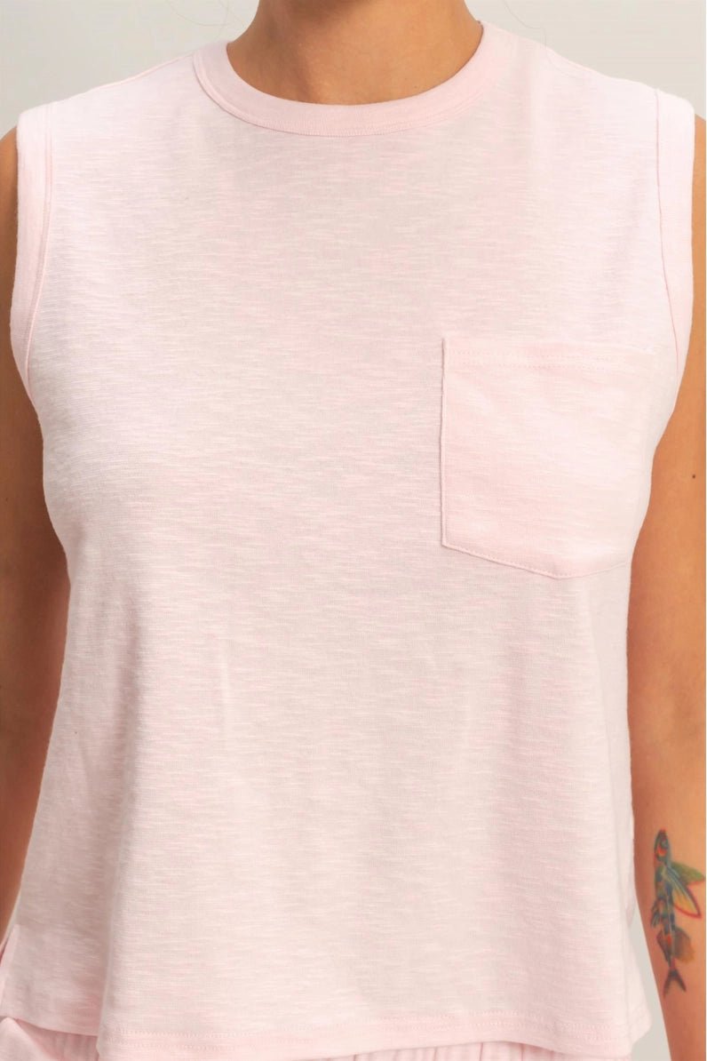 Light pink sleeveless top worn by a person on a white background