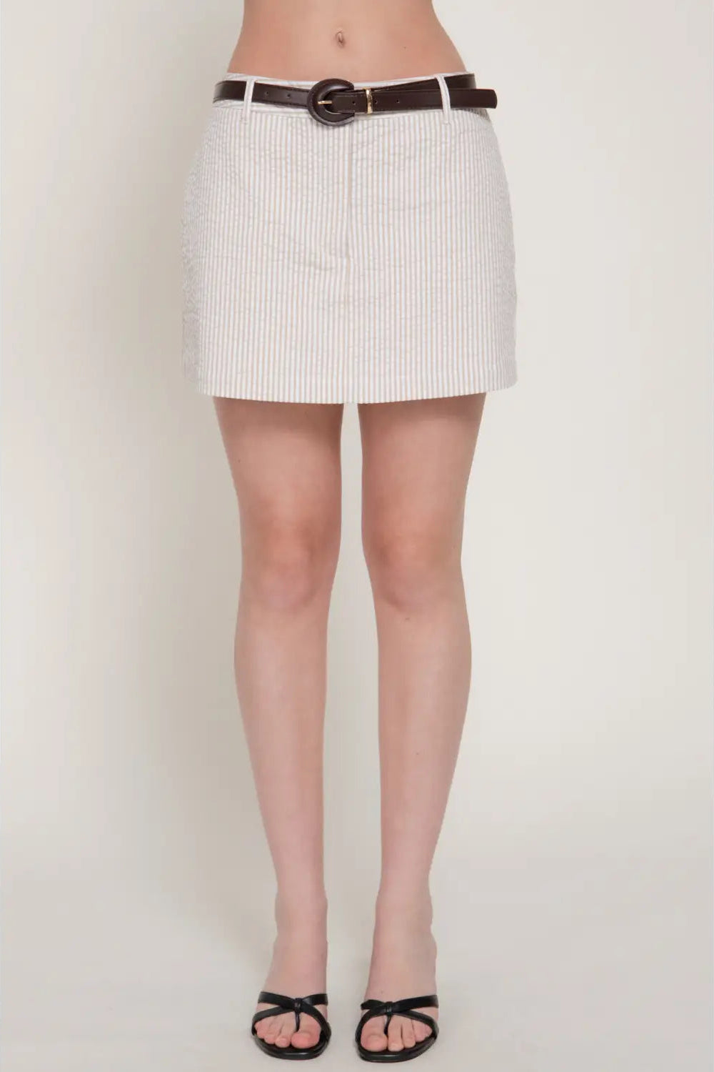 White pinstripe skirt worn by a person on a plain background